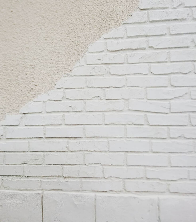 バビクラフトの実績のモルタル造形を施した白いレンガの壁